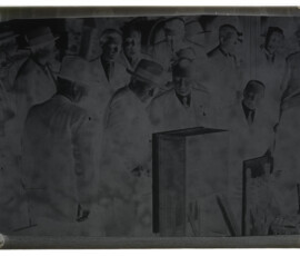 Guido Ucelli e Benito Mussolini, insieme a un gruppo di persone, osservano un motore elettrico
